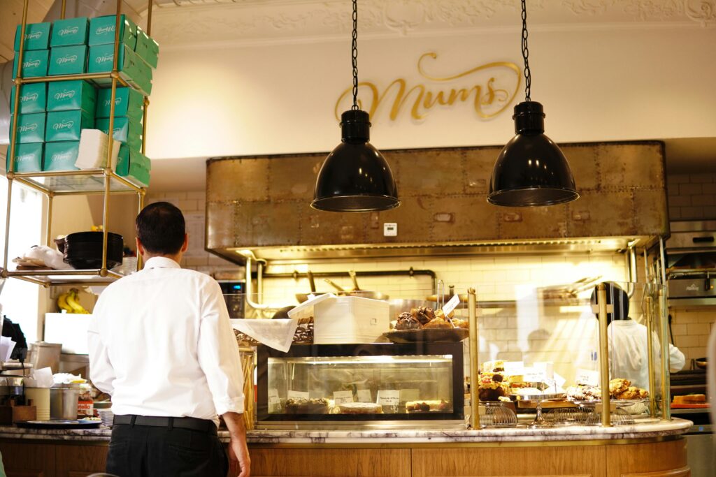 Warm bakery interior with pastry counter and staff, perfect for food and business themes.